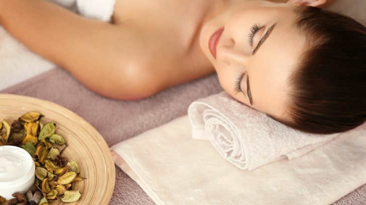 woman laying down beside body butter